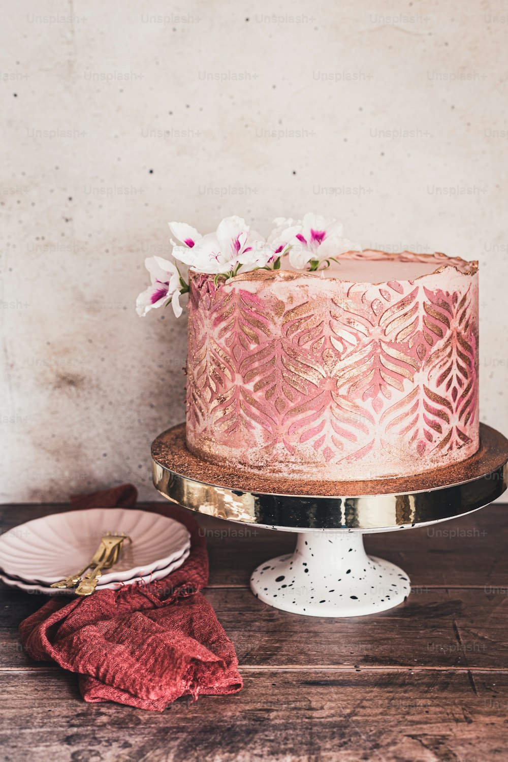 a pink cake sitting on top of a wooden table