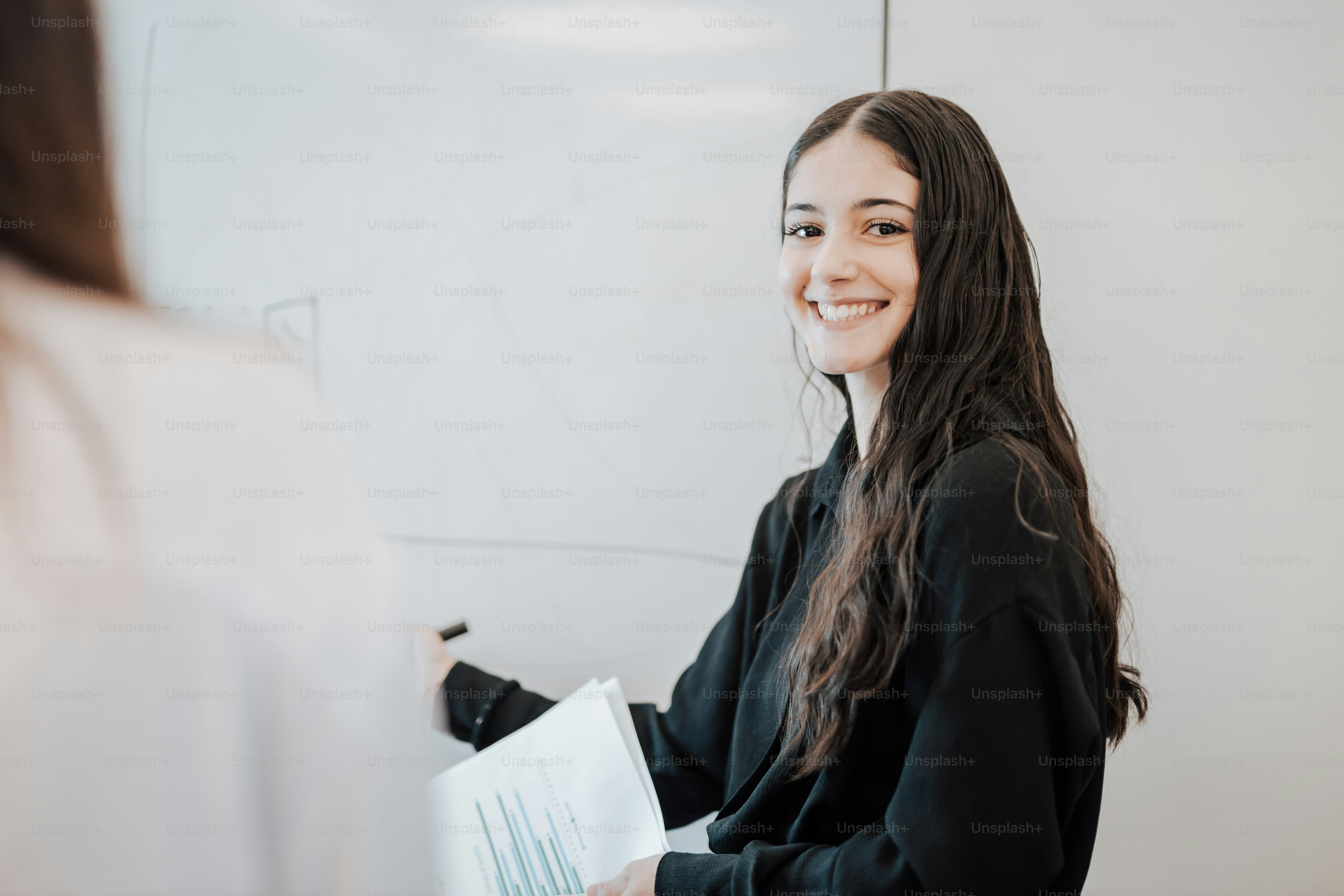 a woman is smiling and holding a piece of paper