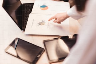 a person pointing at a piece of paper on top of a laptop