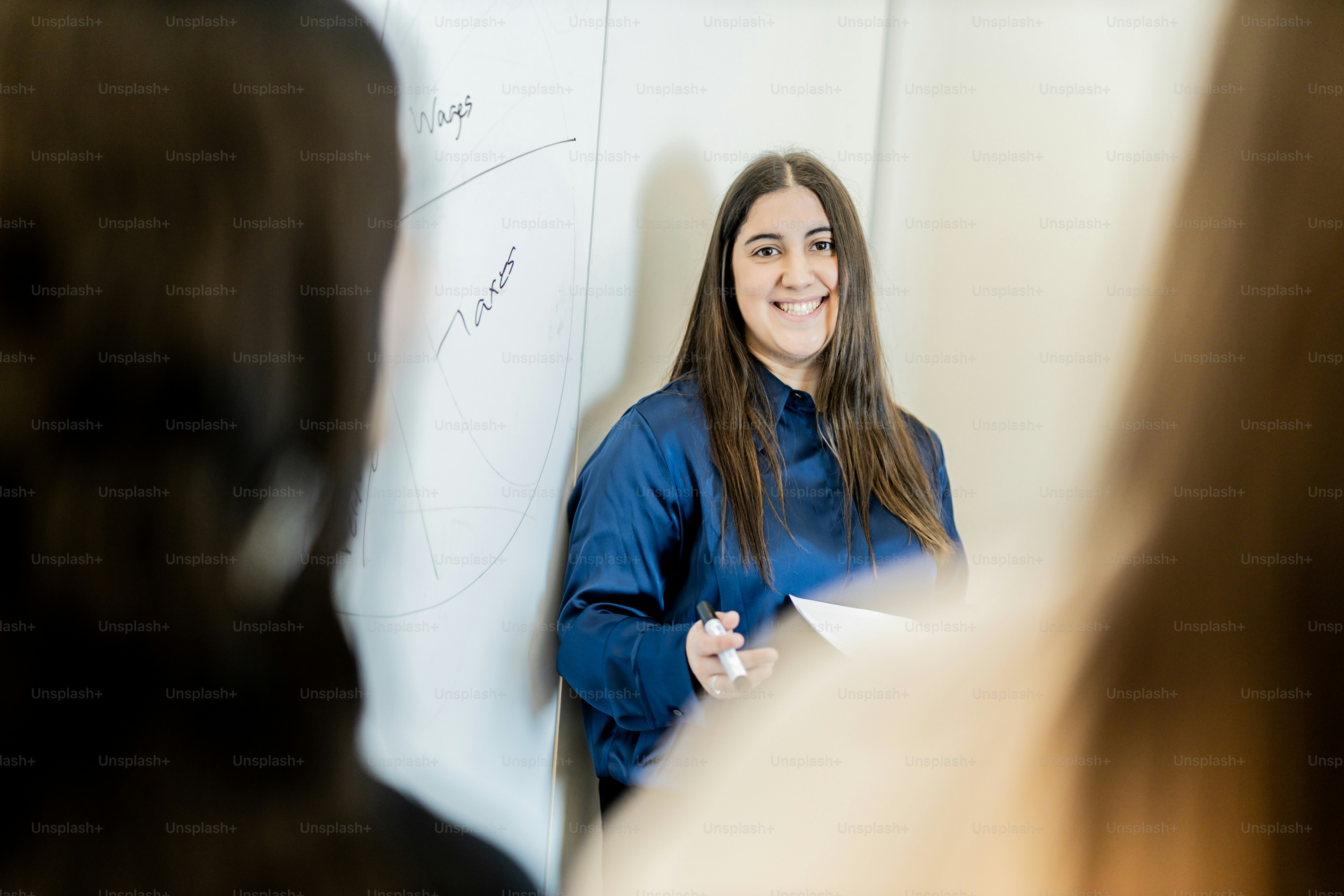 a woman standing in front of a white board