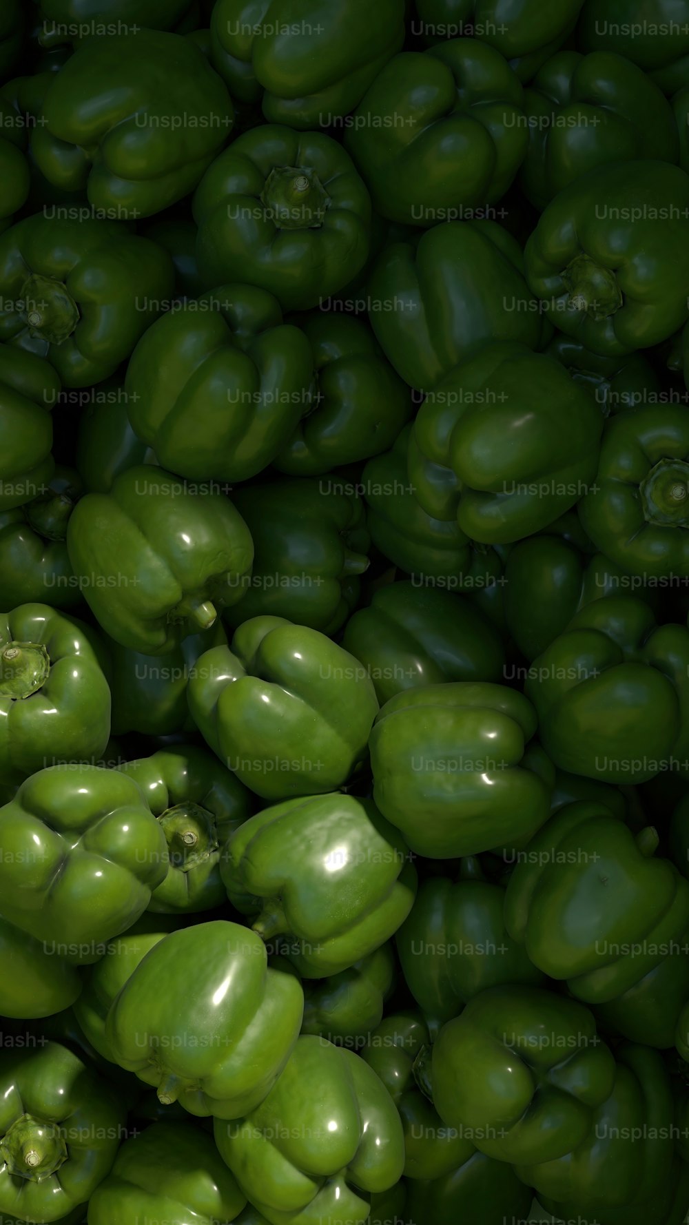 uma grande pilha de pimentões verdes empilhados uns sobre os outros