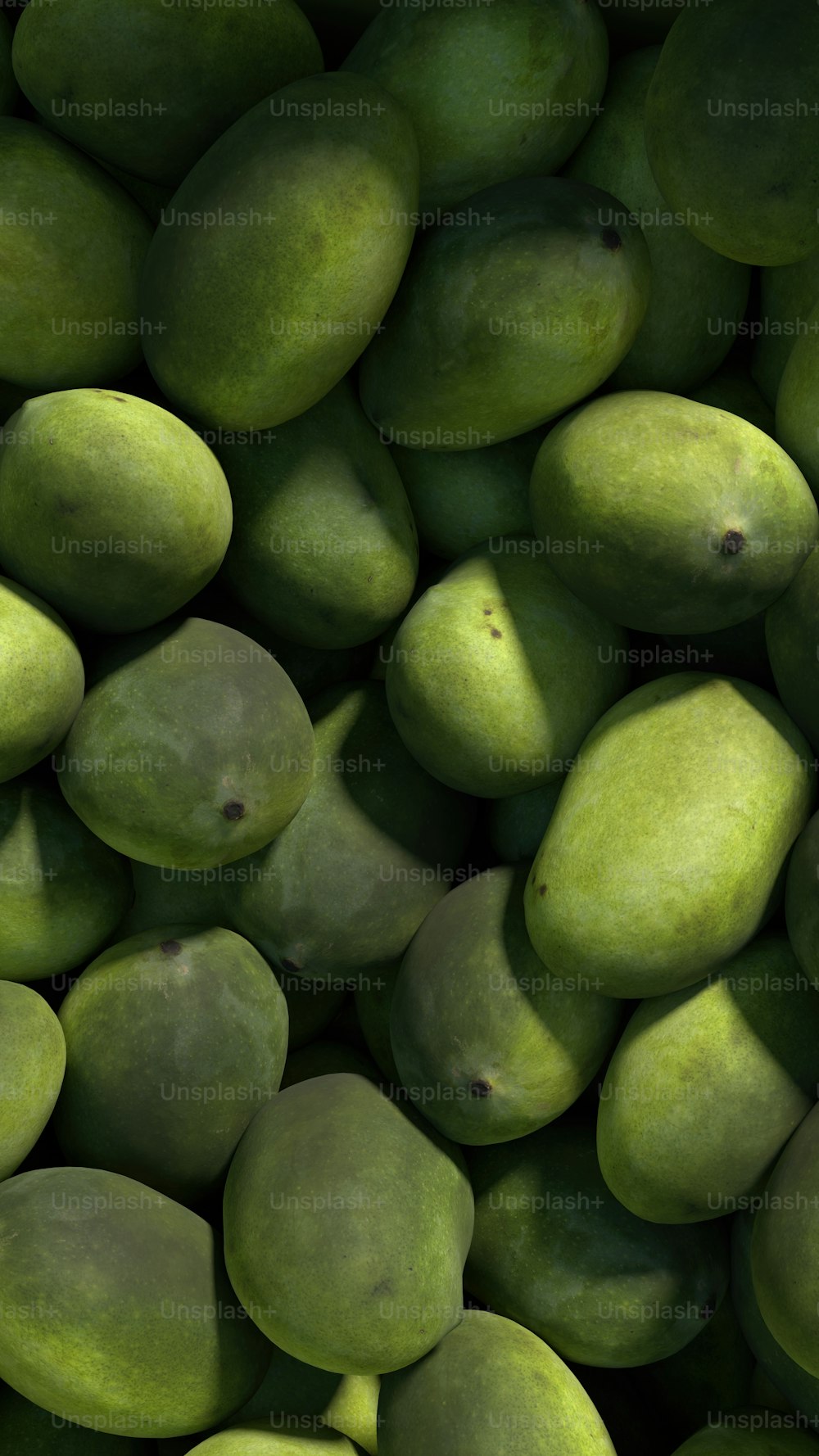 un tas de mangues vertes empilées les unes sur les autres