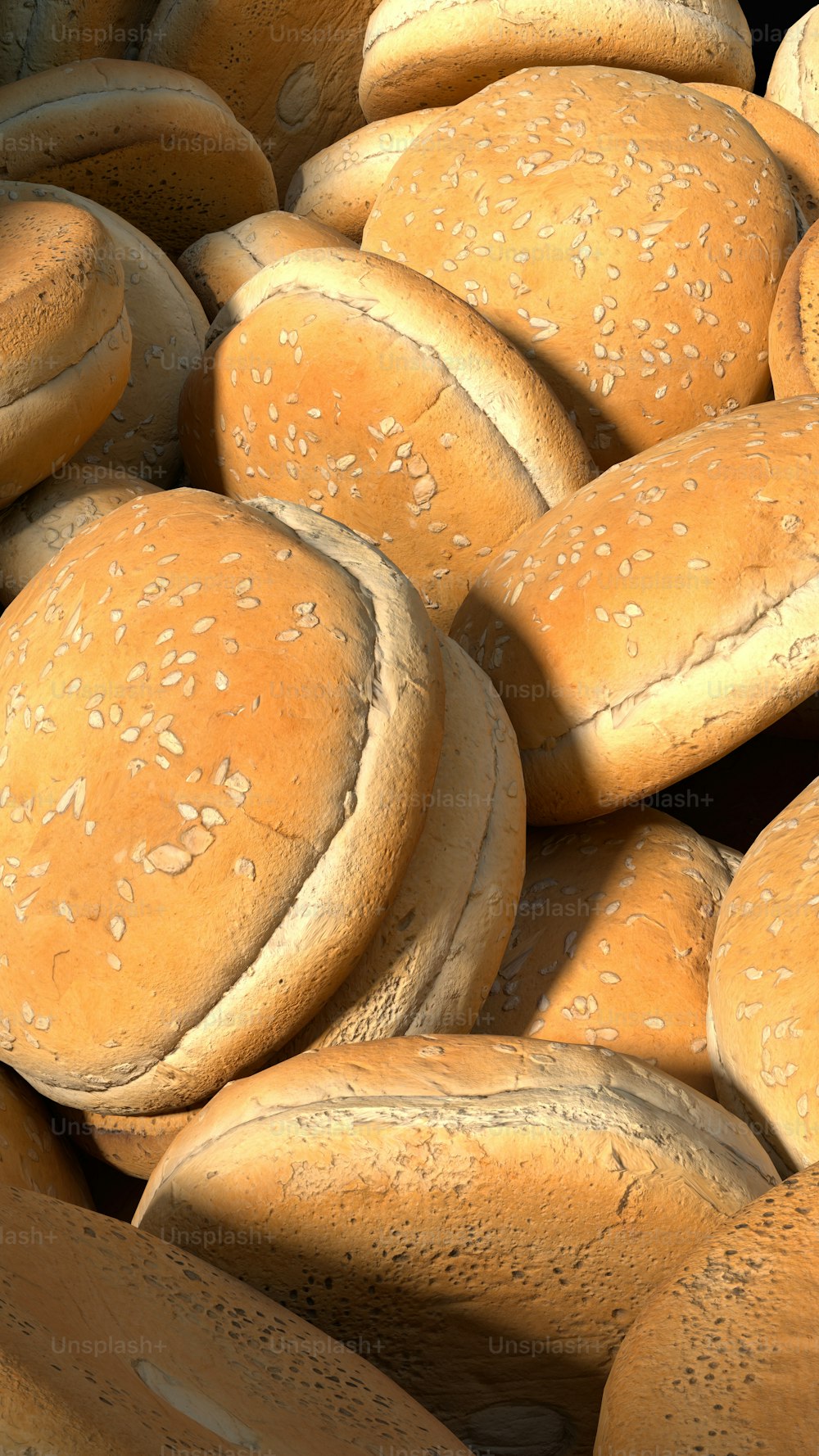 a pile of buns with sesame seeds on them