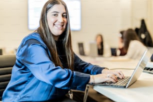 a woman sitting in front of a laptop computer