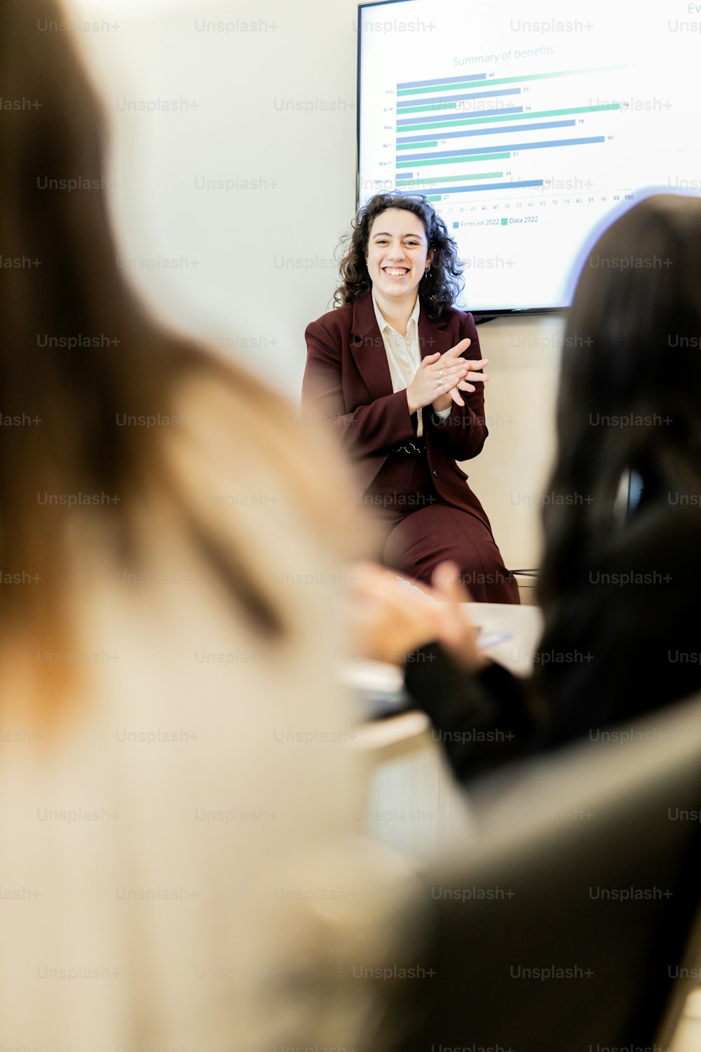a woman in a business suit talking to a group of people