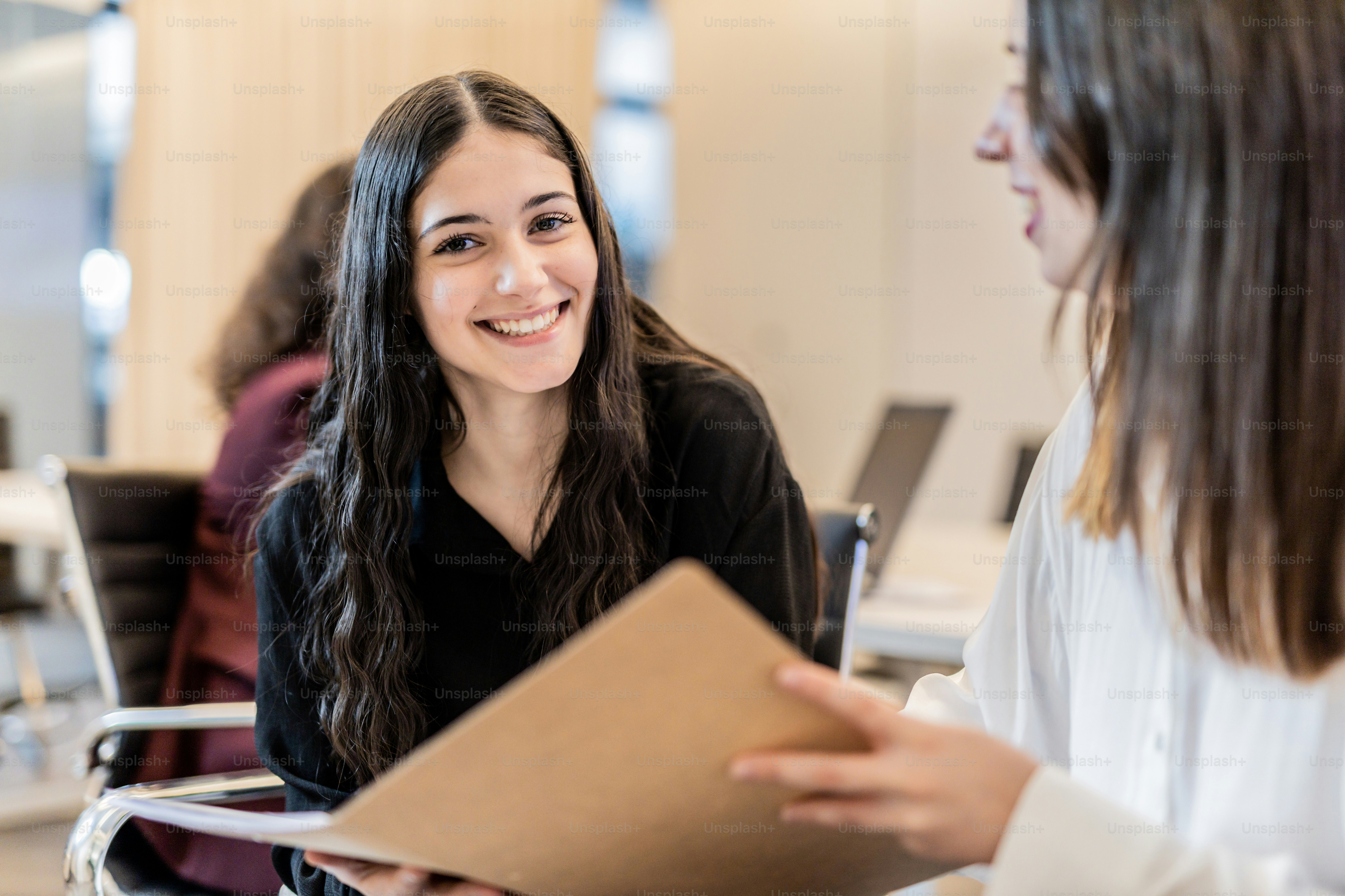 Dos mujeres sentadas en una mesa hablando entre sí