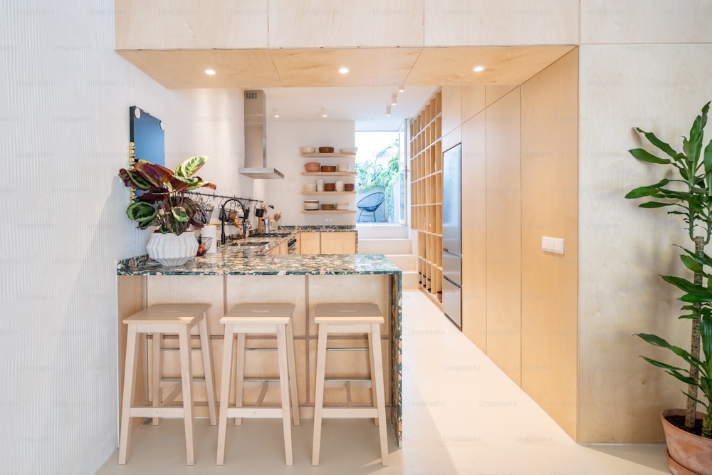 a kitchen with a marble counter top and wooden stools