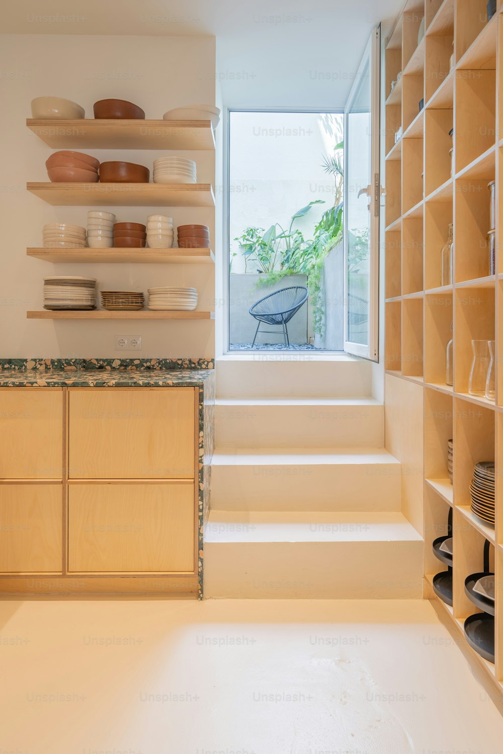 a kitchen with a window and shelves filled with dishes