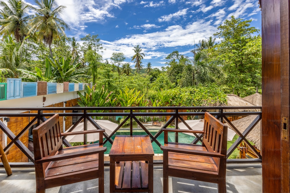 two wooden chairs sitting on top of a balcony