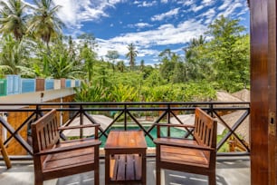 two wooden chairs sitting on top of a balcony