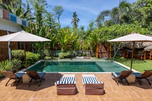 a swimming pool surrounded by lawn chairs and umbrellas