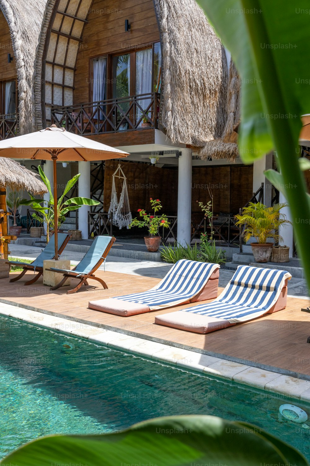 quelques chaises de jardin assises à côté d’une piscine