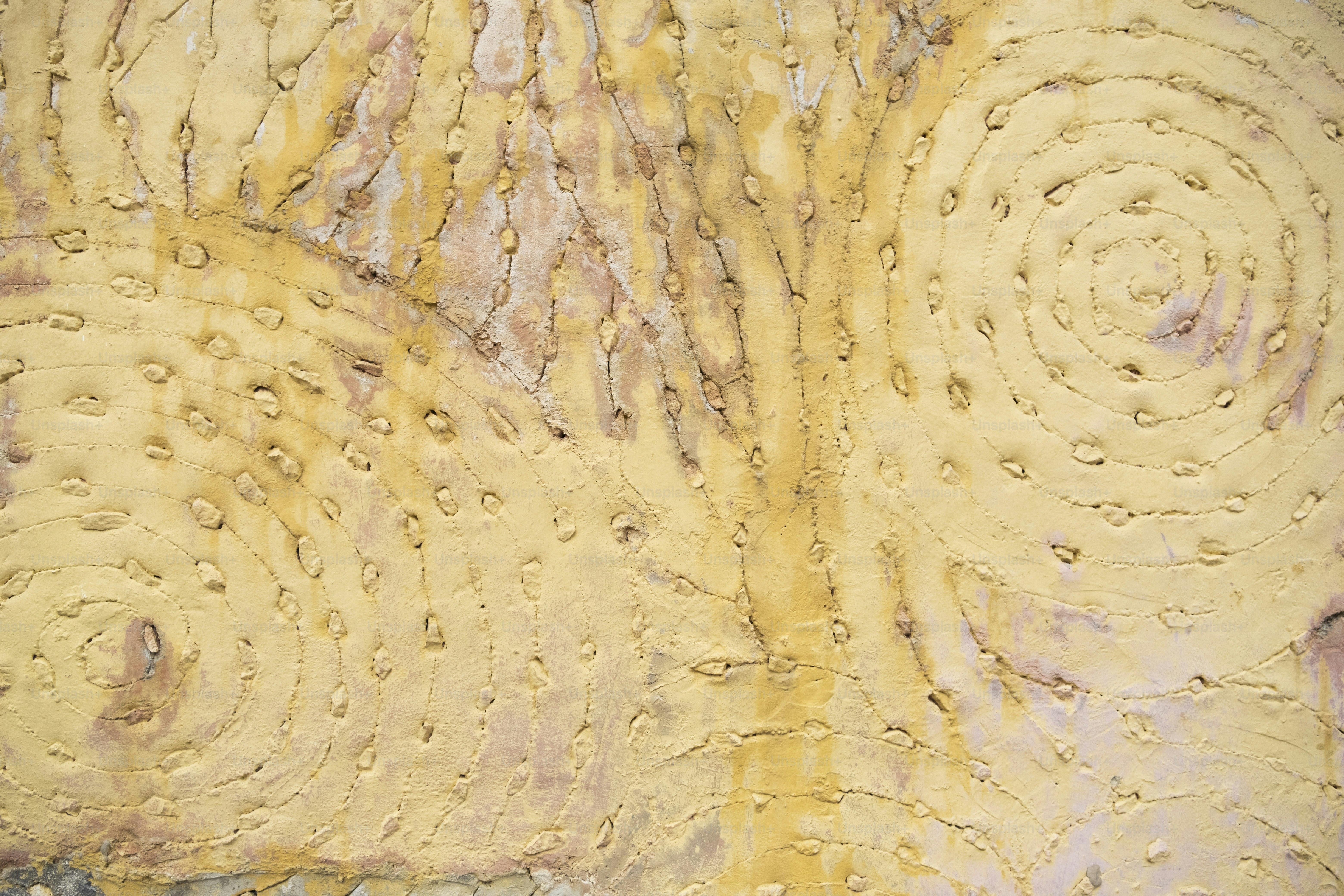 a close up of a yellow wall with circles on it