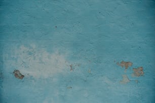 Un idrante rosso seduto di fronte a un muro blu
