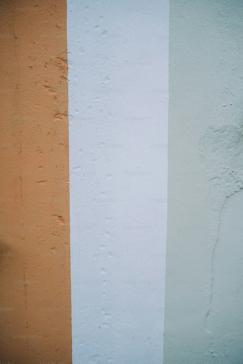 uma parede laranja e branca com um relógio sobre ela