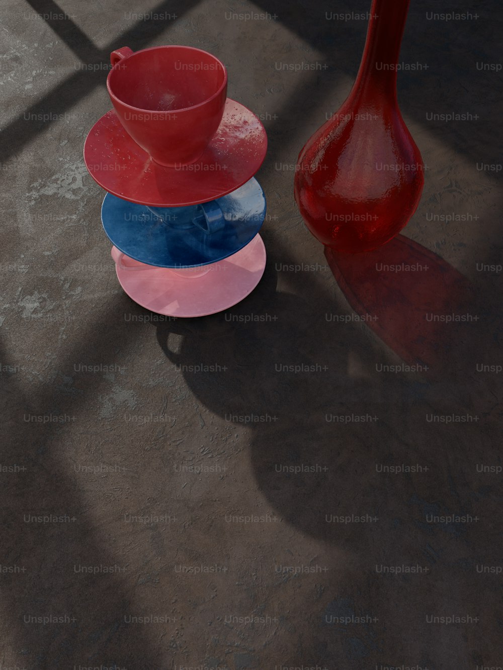 a red vase sitting next to a stack of plates