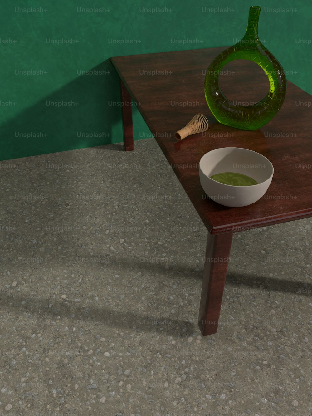 a table with a bowl and a green vase on it