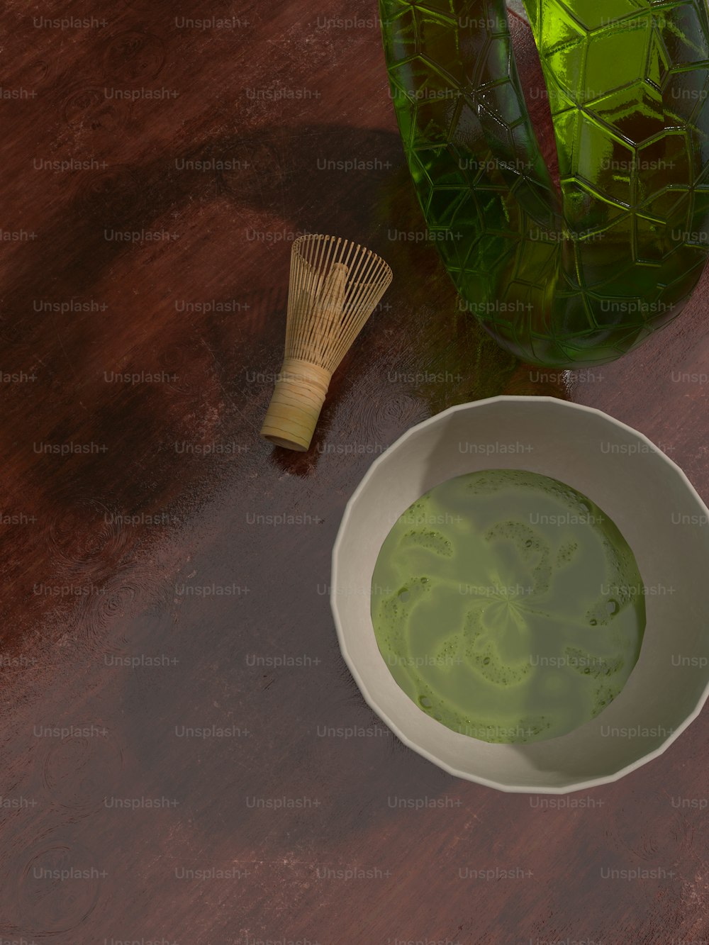 거품기 옆에 녹색 액체 한 그릇