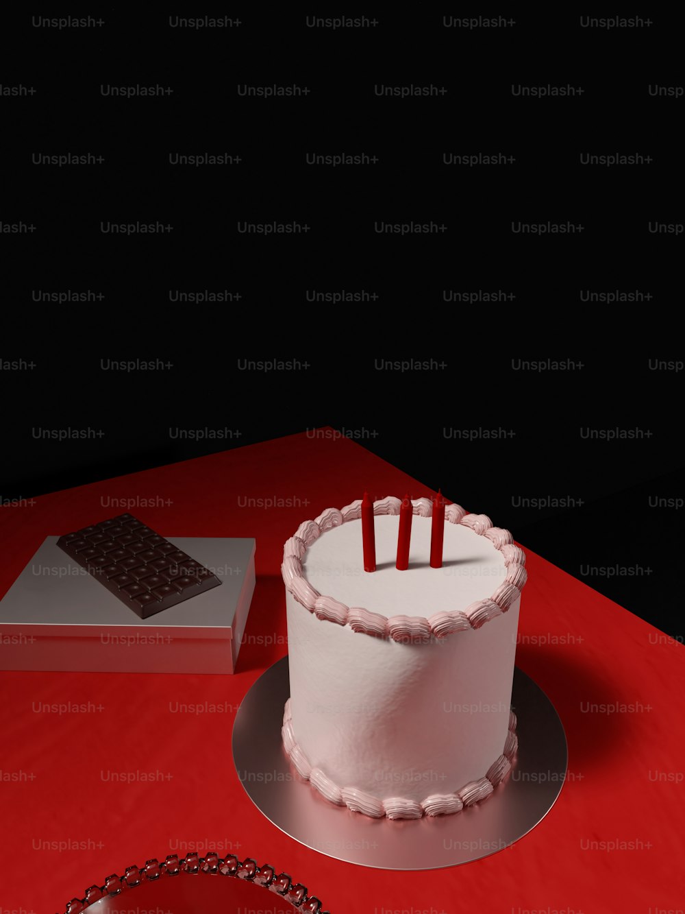 una torta bianca seduta sopra un tavolo rosso