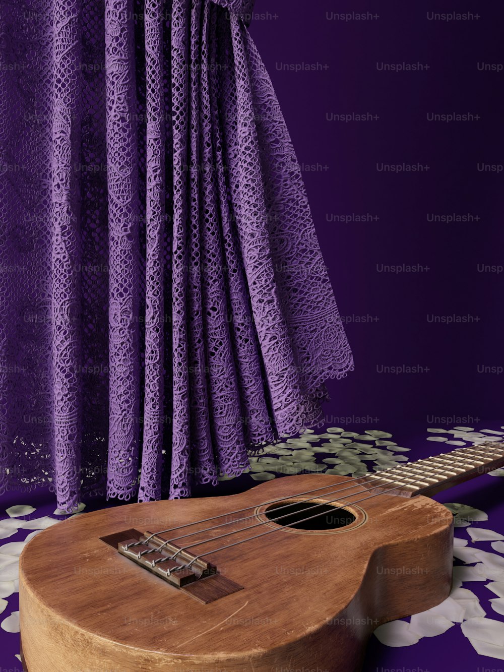 a ukulele sits in front of a purple curtain
