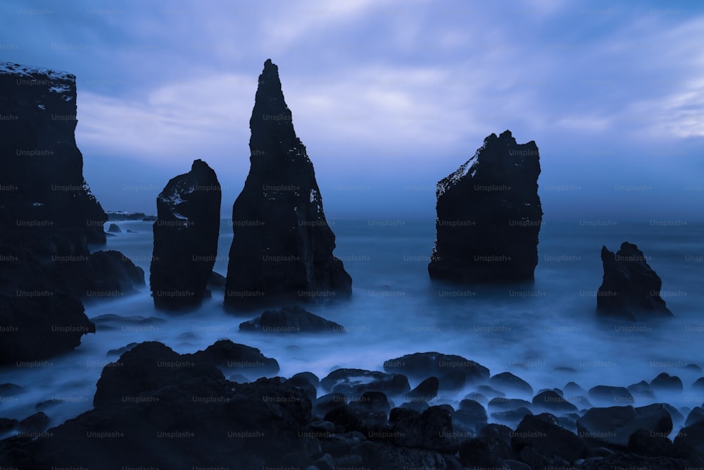 Un grupo de rocas sentadas en la cima de una playa rocosa