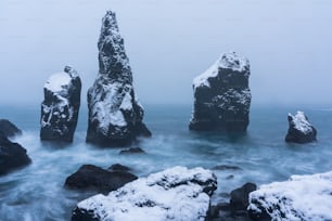 雪に覆われた水中の岩のグループ