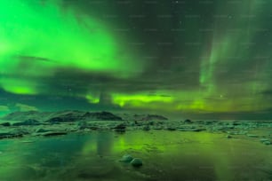 a green and purple aurora bore over a body of water