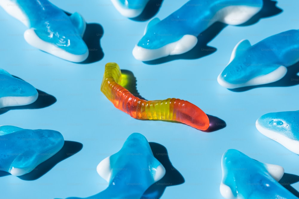 a close up of a candy worm on a blue surface