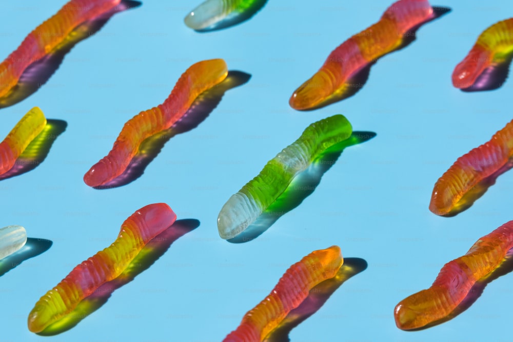 un groupe de poissons gommeux flottant au-dessus d’une surface bleue