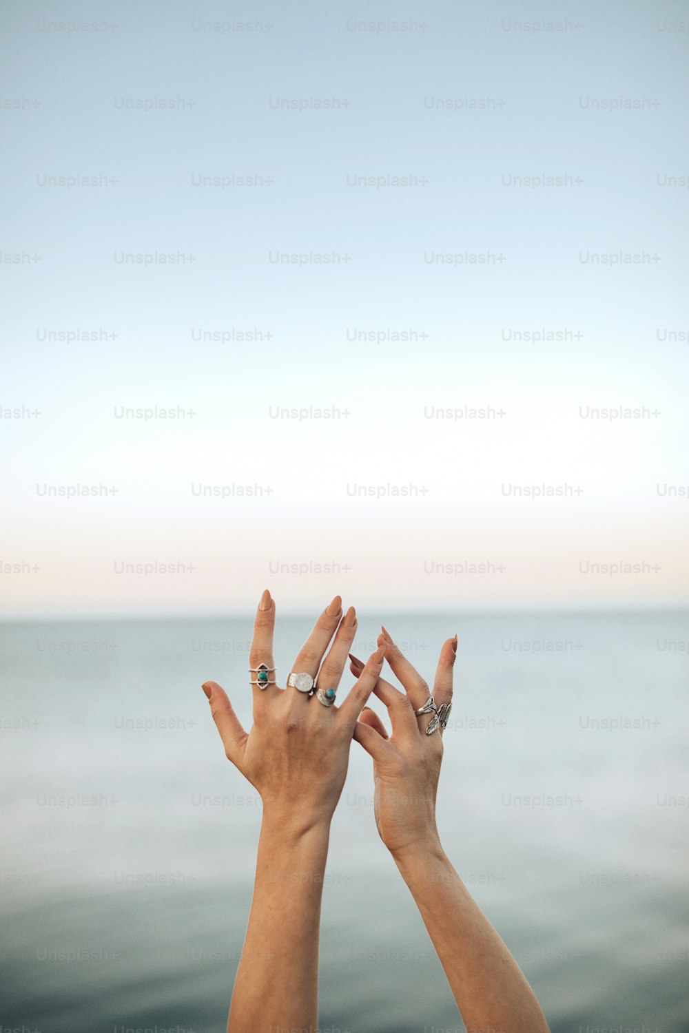 duas mãos estendendo-se para o ar acima da água