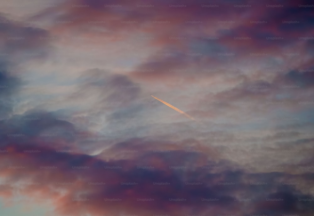 Un aereo sta volando attraverso un cielo nuvoloso