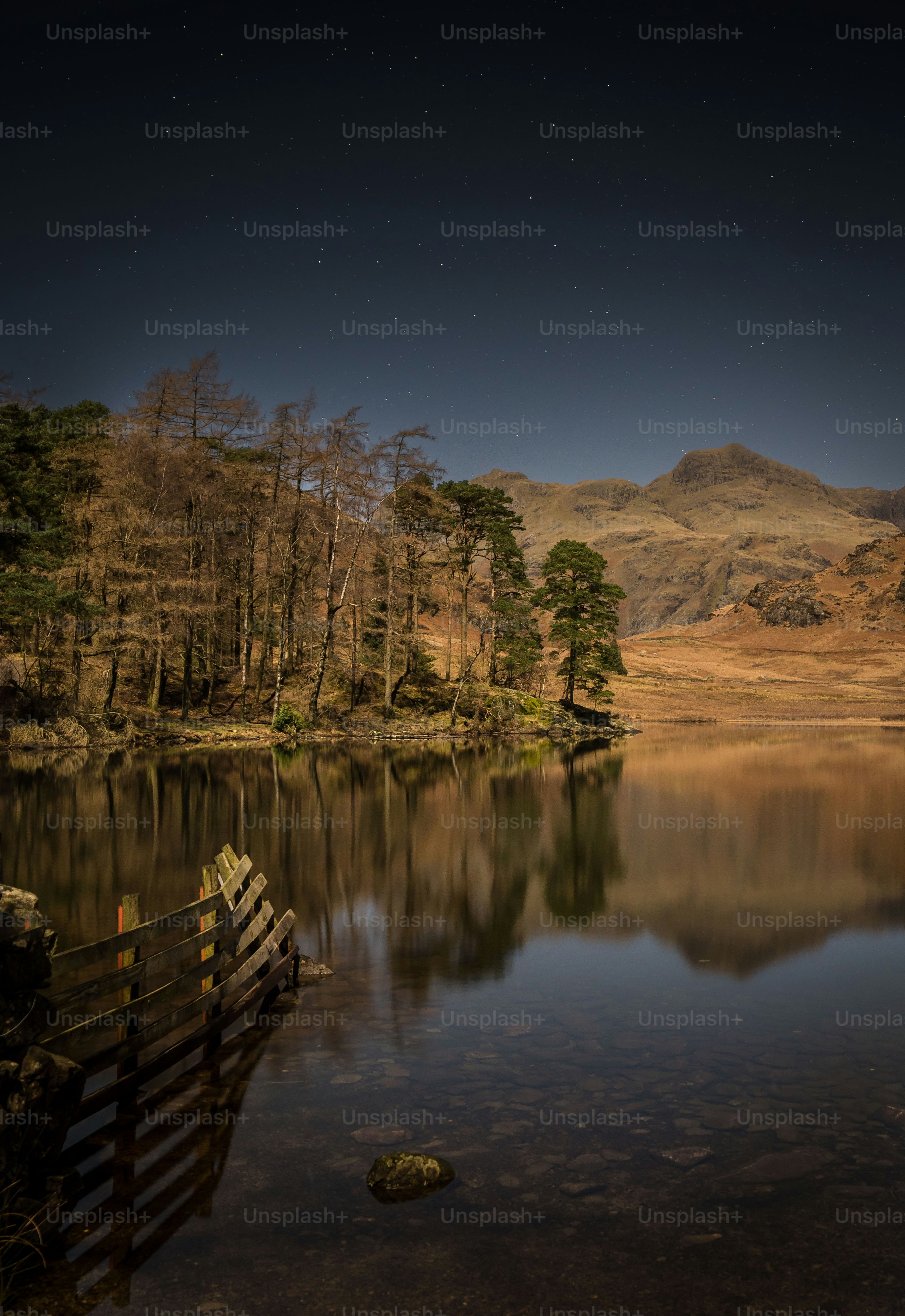 A lake surrounded by mountains under a night sky photo – Wallpapers ...