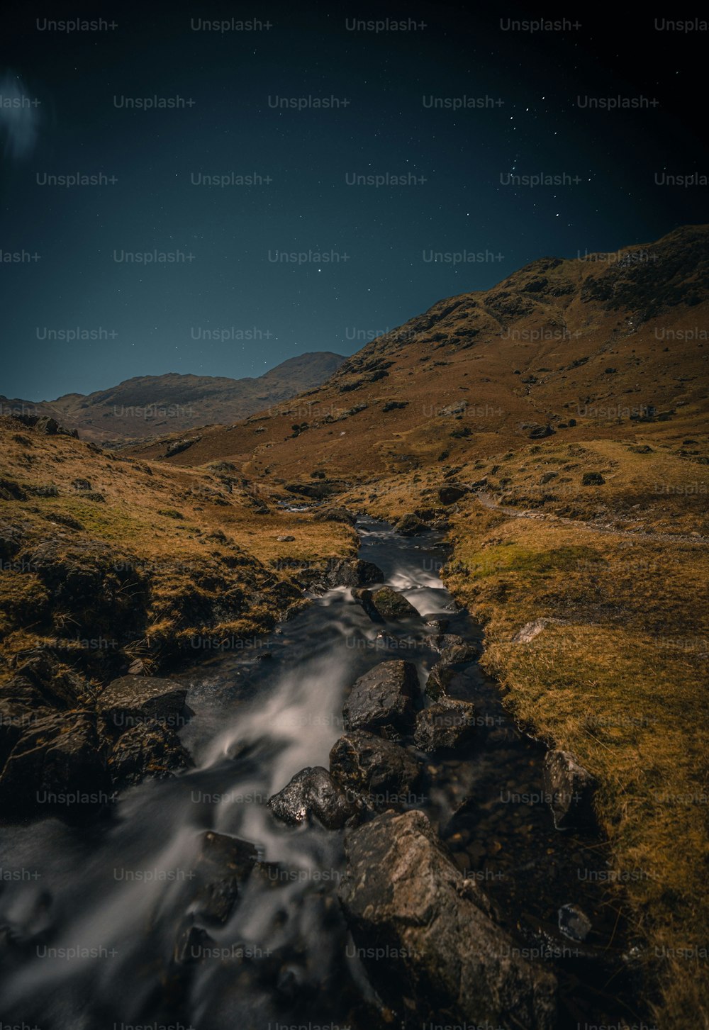 a stream running through a lush green hillside