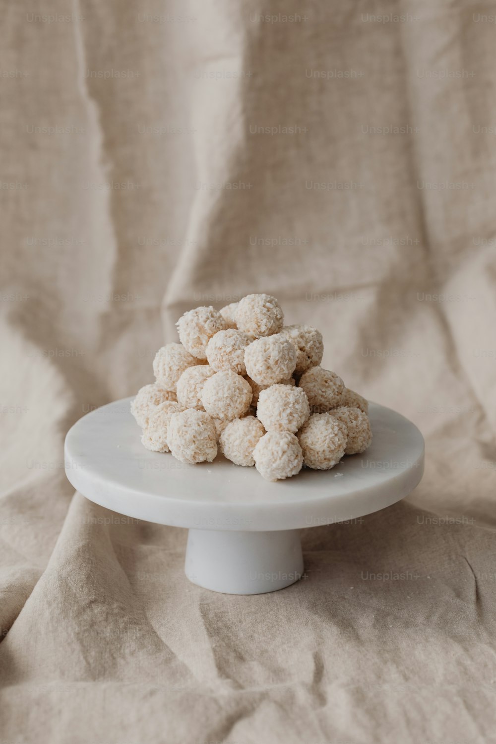 a white plate topped with a pile of snowballs