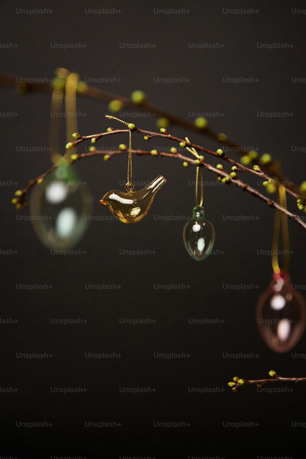 a branch with three ornaments hanging from it