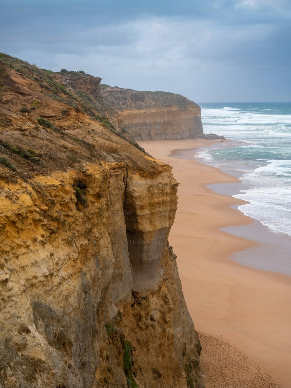 a rocky cliff overlooks the beach and ocean