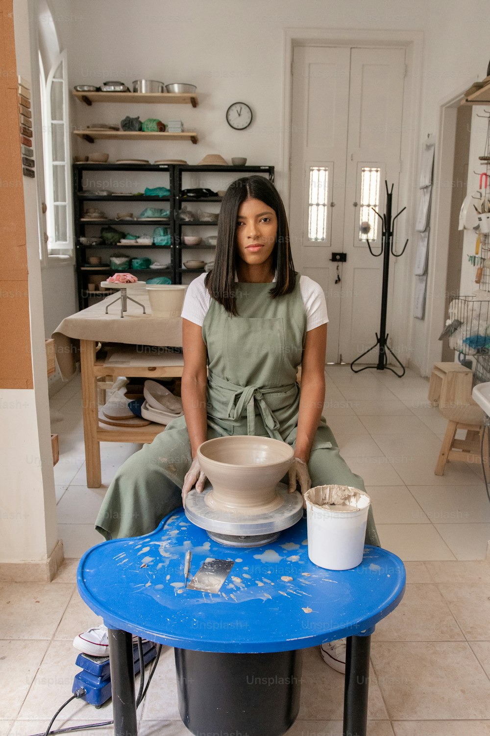 a woman sitting on a table with a bowl on it