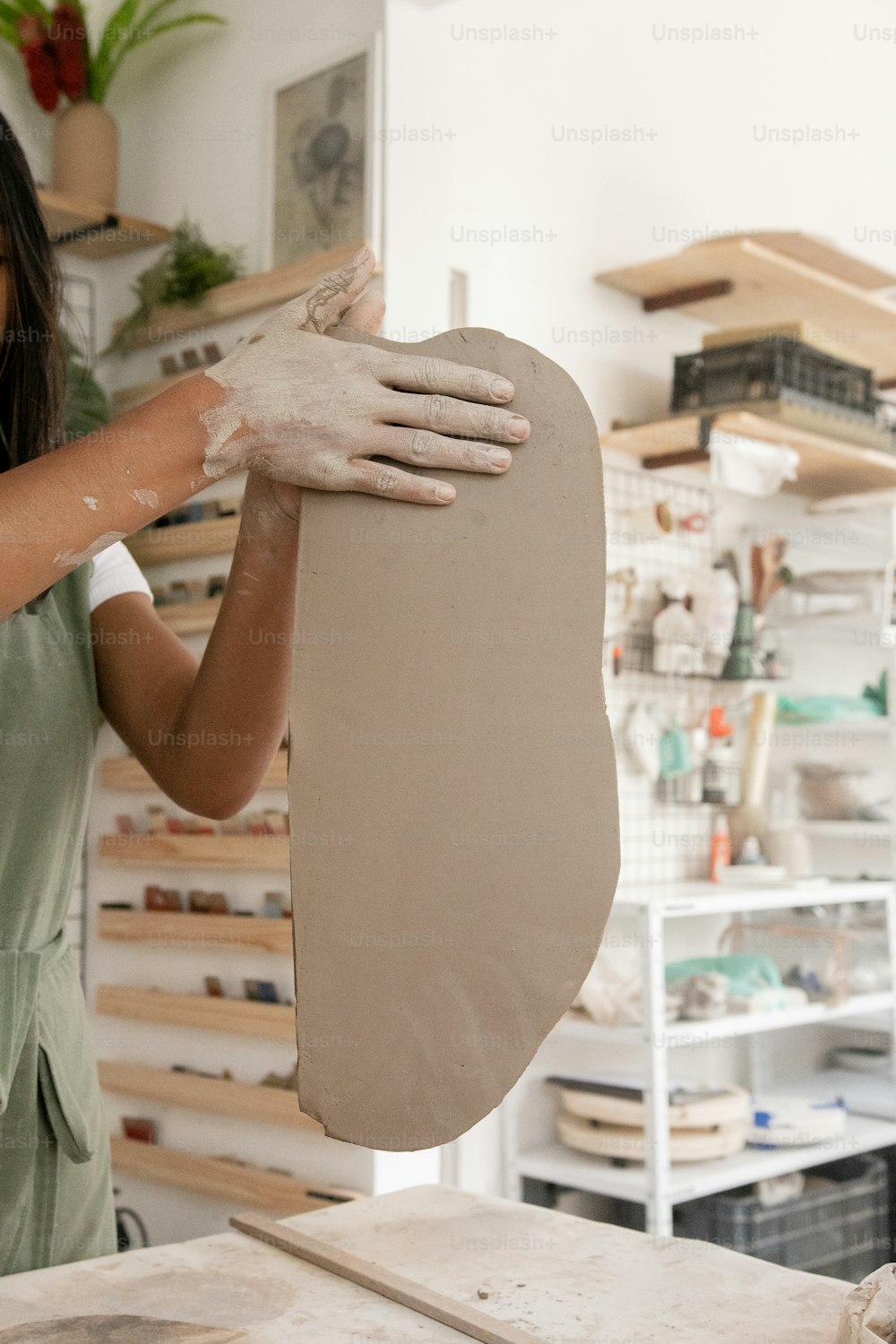 女性がスタジオで粘土の彫刻を作っている