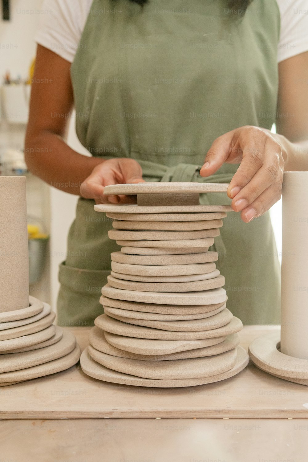 a woman is making a stack of plates