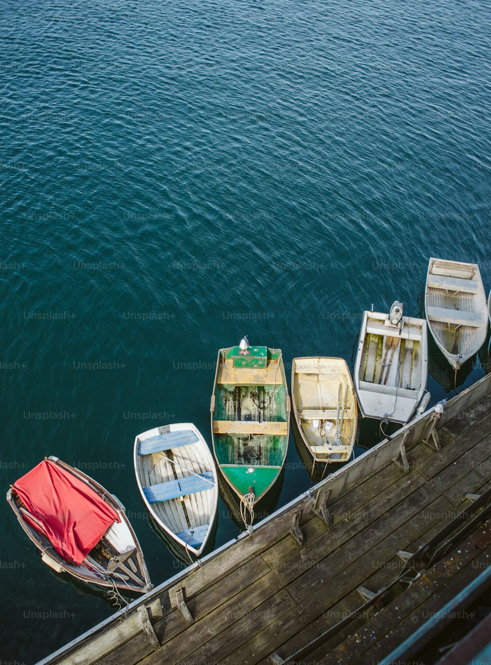 Un grupo de pequeños botes sentados encima de un cuerpo de agua