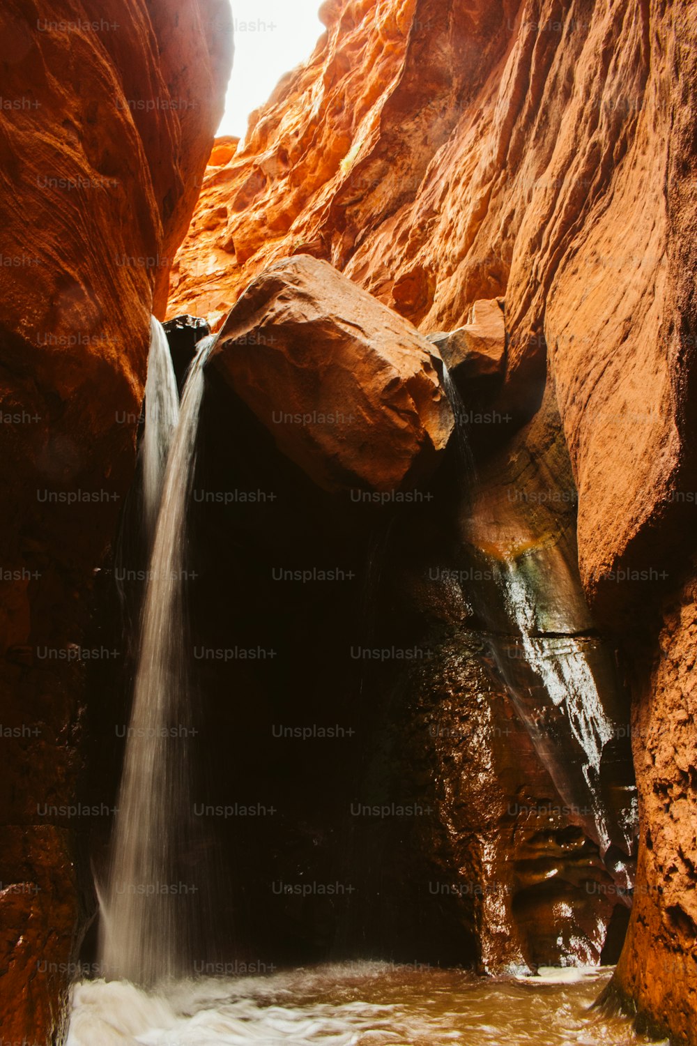 a small waterfall in the middle of a canyon