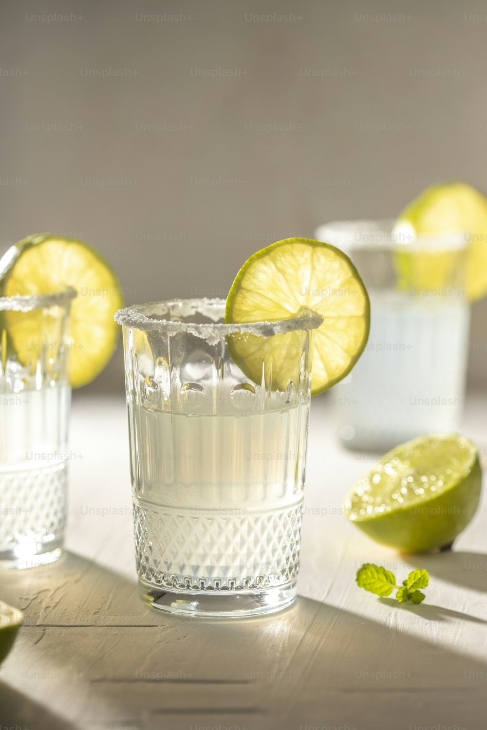 two glasses of water with limes and a lime slice