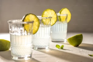 drei Gläser Wasser mit Limetten an der Seite