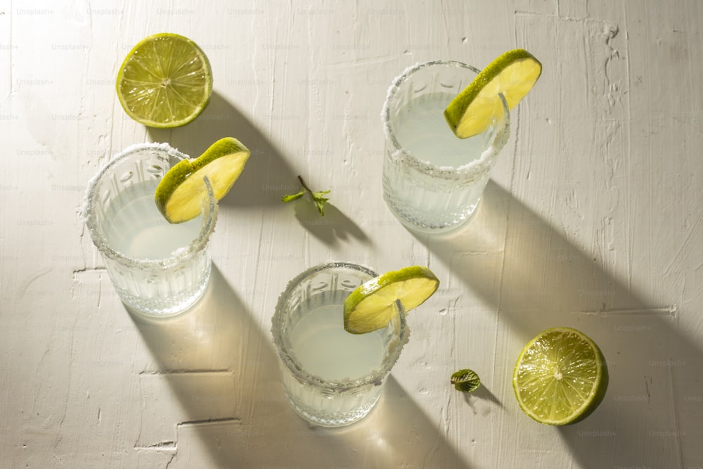 three glasses of water with limes and a slice of lime