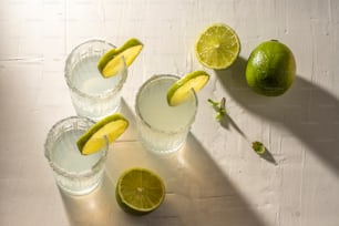 Trois verres d’eau avec des citrons verts sur une table