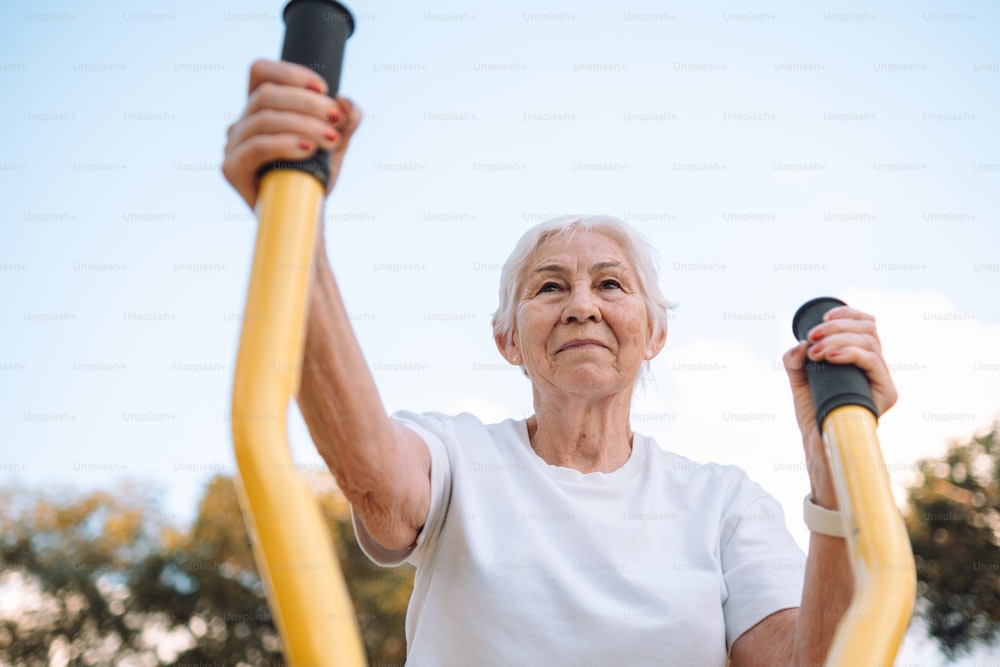an older woman is holding a pair of exercise equipment