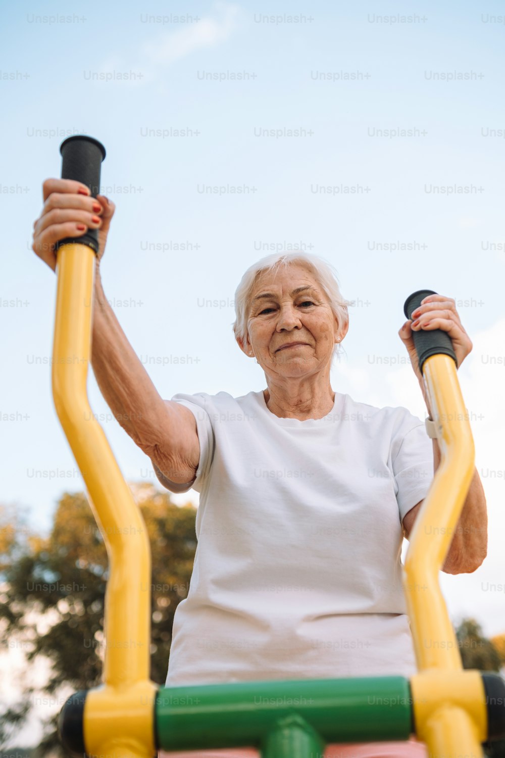 두 개의 운동 막대를 손에 들고 있는 노인 여성