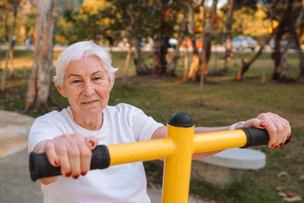 Une femme âgée sur un vélo jaune dans un parc