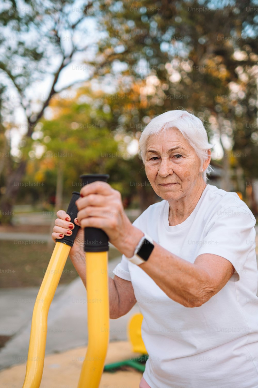 an older woman holding a yellow hose in her hands