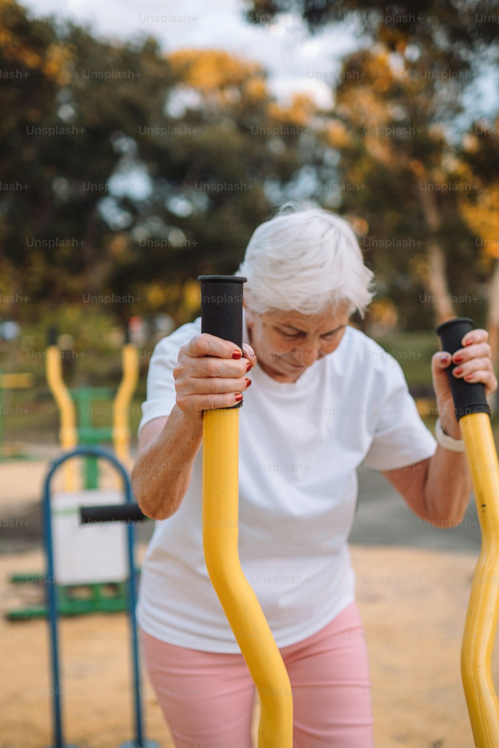 uma mulher mais velha segurando um par de equipamentos de exercício
